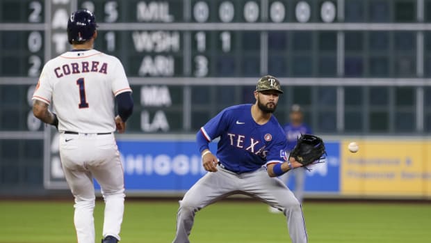 May 15, 2021; Houston, Texas, USA; Texas Rangers shortstop Isiah Kiner-Falefa (9) forces out Houston Astros shortstop Carlos Correa (1) at second base in the fifth inning at Minute Maid Park.